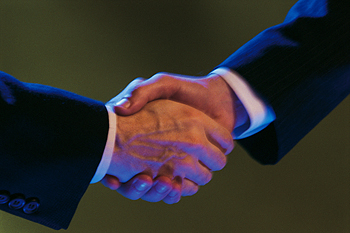 Two hands in business suits shaking hands