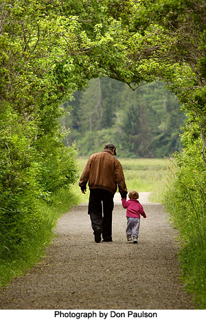 Man and child on park path by Don Paulson